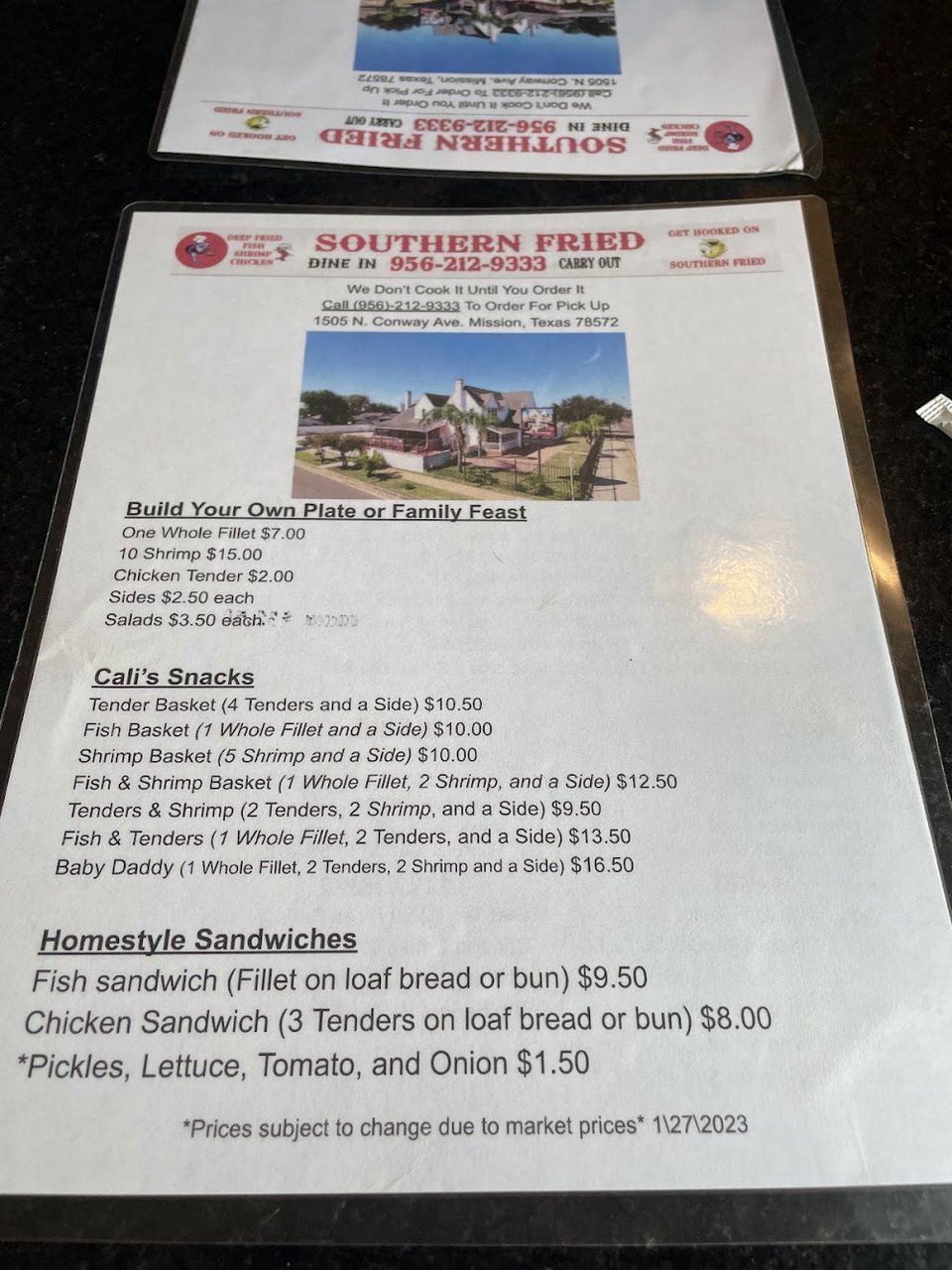 Restaurant menu listing chicken tenders and shrimp baskets.
